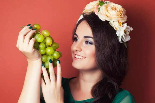 Mulher usando grinalda e segurando uvas verdes — Fotografia de Stock