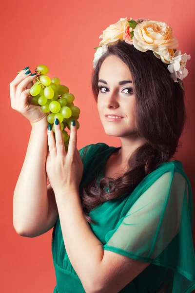 Mujer con corona y sosteniendo uvas verdes — Foto de Stock