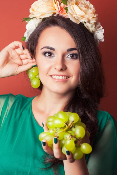 Mujer con corona y sosteniendo uvas verdes — Foto de Stock
