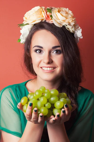 Mujer con corona y sosteniendo uvas verdes — Foto de Stock