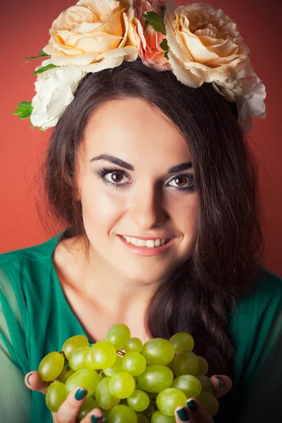Mulher usando grinalda e segurando uvas verdes — Fotografia de Stock