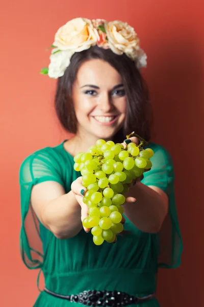 Mujer con corona y sosteniendo uvas verdes — Foto de Stock