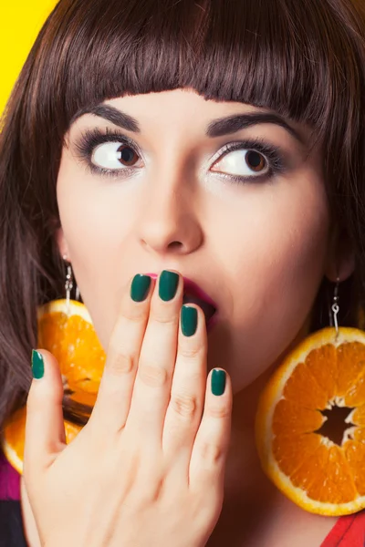 Emocionální žena nosí náušnice vyrobené z oranžové — Stock fotografie