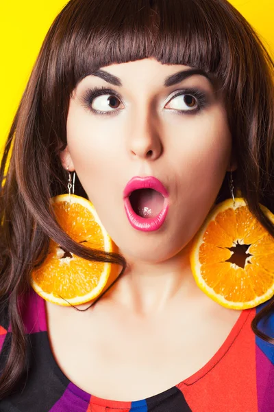 Mulher emocional usando brincos feitos de laranja — Fotografia de Stock