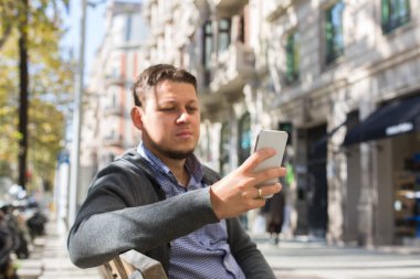 Genç adam sokakta yürüyor ve telefonla konuşuyor..