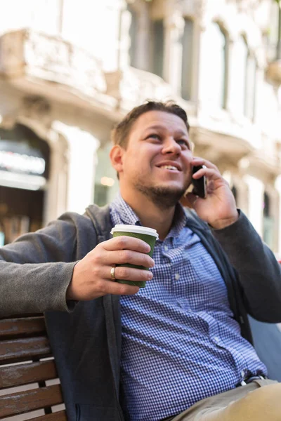 Homem andando na rua, bebendo café, conversando por telefone — Fotografia de Stock