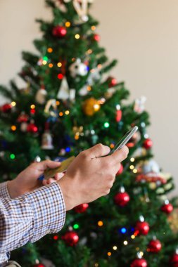 Adam Noel 'i satın alıyor, yeni yıl hediyelerini internetten alıyor telefon, dizüstü bilgisayar kullanarak