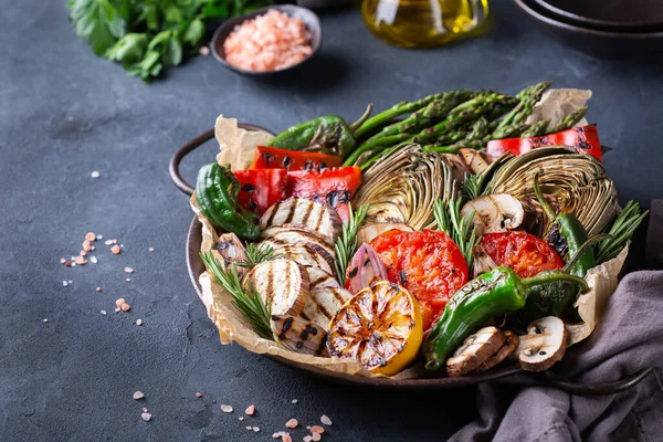 Vegan, vegetarian, seasonal, summer eating concept. Grilled vegetables in a pan on a dark black table