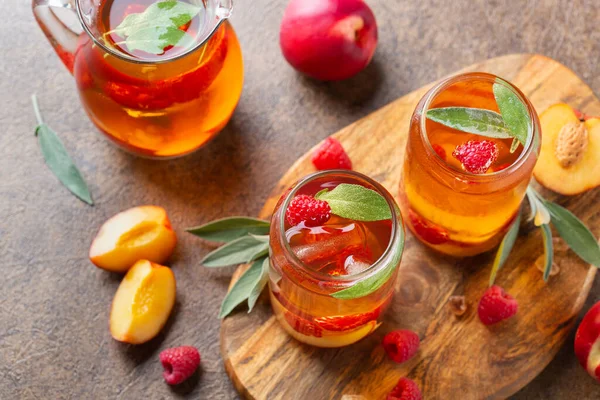 Peach raspberry iced tea with sage. Summer refreshing drink, beverage, cocktail