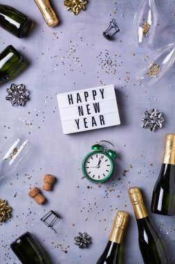 Şampanya bardakları, şişeler, ışıltılar, konfetiler. Yukarıdan bak, gümüş ve altın renkler