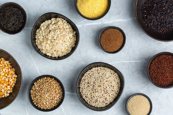 Healthy eating, dieting, balanced food concept. Assortment of gluten free cereals, corn, rice, amaranth, teff, buckwheat, quinoa and oat on a table. Top view flat lay background