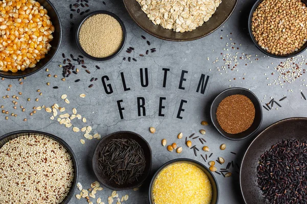 Healthy eating, dieting, balanced food concept. Assortment of gluten free cereals, corn, rice, amaranth, teff, buckwheat, quinoa and oat on a table. Top view flat lay background