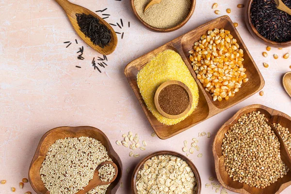 Healthy eating, dieting, balanced food concept. Assortment of gluten free cereals, corn, rice, amaranth, teff, buckwheat, quinoa and oat on a table. Top view flat lay background