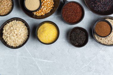Healthy eating, dieting, balanced food concept. Assortment of gluten free cereals, corn, rice, amaranth, teff, buckwheat, quinoa and oat on a table. Top view flat lay background