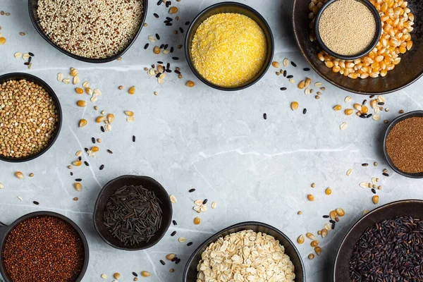 Healthy eating, dieting, balanced food concept. Assortment of gluten free cereals, corn, rice, amaranth, teff, buckwheat, quinoa and oat on a table. Top view flat lay background