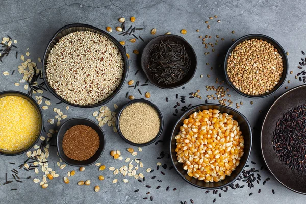 Healthy eating, dieting, balanced food concept. Assortment of gluten free cereals, corn, rice, amaranth, teff, buckwheat, quinoa and oat on a table. Top view flat lay background