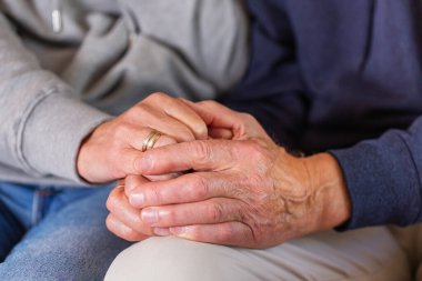 Senior married couple holding hands together. Family, help, elderly care and support concept