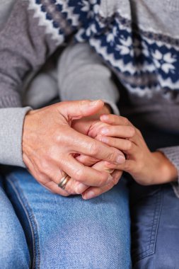 Senior woman and a child holding hands together. Family, help, elderly care and support concept