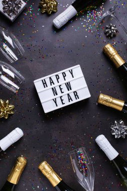 Şampanya bardakları, şişeler, ışıltılar, konfetiler. Yukarıdan bak, gümüş ve altın renkler