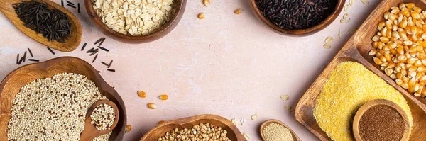 Healthy eating, dieting, balanced food concept. Assortment of gluten free cereals, corn, rice, amaranth, teff, buckwheat, quinoa and oat on a table. Top view flat lay background, banner