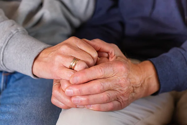 Senior married couple holding hands together. Family, help, elderly care and support concept