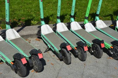 Lviv. Ukrayna. Şehir sokaklarında Mayıs 2021 'de kiralık elektrikli scooter' lar. Şehirde her gün elektrikli scooter ekonomik araç kullanılıyor. Limon kiralama mobiletlerinin sokak manzarası bir iş yerinin önünde sıralanmıştı.