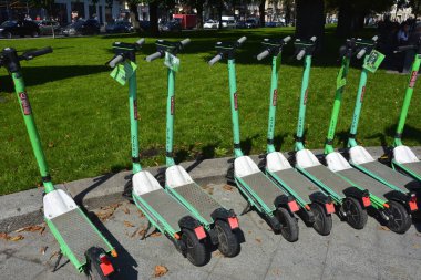 Lviv. Ukrayna. Şehir sokaklarında Mayıs 2021 'de kiralık elektrikli scooter' lar. Şehirde her gün elektrikli scooter ekonomik araç kullanılıyor. Limon kiralama mobiletlerinin sokak manzarası bir iş yerinin önünde sıralanmıştı.