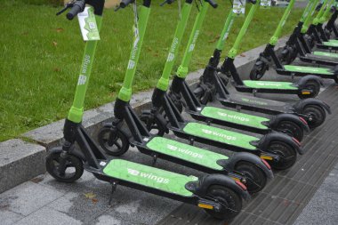 Lviv. Ukrayna. Şehir sokaklarında Mayıs 2021 'de kiralık elektrikli scooter' lar. Şehirde her gün elektrikli scooter ekonomik araç kullanılıyor. Limon kiralama mobiletlerinin sokak manzarası bir iş yerinin önünde sıralanmıştı.