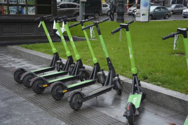 Lviv. Ukrayna. Şehir sokaklarında Mayıs 2021 'de kiralık elektrikli scooter' lar. Şehirde her gün elektrikli scooter ekonomik araç kullanılıyor. Limon kiralama mobiletlerinin sokak manzarası bir iş yerinin önünde sıralanmıştı.