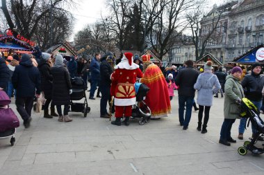 Lviv, Ukrayna - Aralık 2021: Lviv Noel Fuarı 2021. Yeni yıl ve Noel kutlamaları sırasında Nicholas ve Noel Baba.