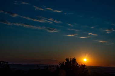 Turuncu gökyüzünde gümüş astar ve bulutla güçlü gündoğumunun muhteşem manzarası..