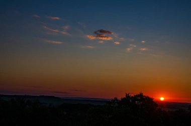 Turuncu gökyüzünde gümüş astar ve bulutla güçlü gündoğumunun muhteşem manzarası..