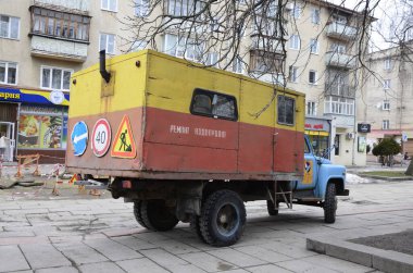 Rivne. Ukraine. November, 2021.municipal blue red yellow color ussr old electric service and water supply repair GAZ 53, vintage classic car arriving on emergency call drive on city urban street
