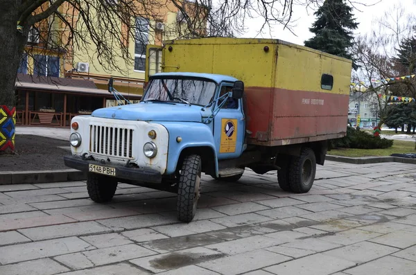 Rivne. Ukraine. November, 2021.municipal blue red yellow color ussr old electric service and water supply repair GAZ 53, vintage classic car arriving on emergency call drive on city urban street