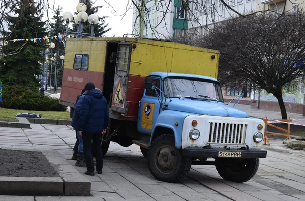 Rivne. Ukraine. November, 2021.municipal blue red yellow color ussr old electric service and water supply repair GAZ 53, vintage classic car arriving on emergency call drive on city urban street