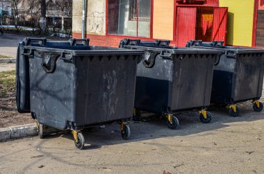 Şehir çöp konteynırları. Çöp kamyonu yolda bekliyor..