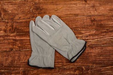 Ahşap arka planda kirli deri iş eldivenleri. Ahşap masa üzerinde çalışan eldivenler, inşaat aletleri