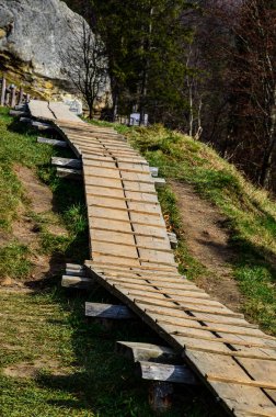 Dönek orman yolu. Kayalık arazide ahşap yol, ahşap köprü.