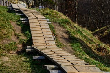 Dönek orman yolu. Kayalık arazide ahşap yol, ahşap köprü.