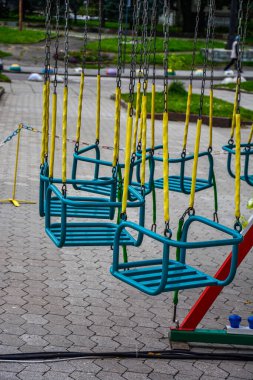 Atlıkarınca çocuk koltukları lunaparkta hızla koşuyor. Boş çocukların atlıkarıncaları kanatlarda bekliyor.