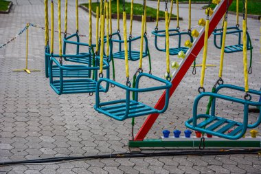 Atlıkarınca çocuk koltukları lunaparkta hızla koşuyor. Boş çocukların atlıkarıncaları kanatlarda bekliyor.