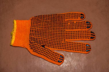 Turuncu iş eldivenleri bahçedeki ahşap bir tahtanın üzerinde yatıyor. .