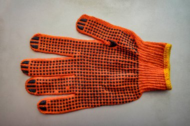 Turuncu iş eldivenleri bahçedeki ahşap bir tahtanın üzerinde yatıyor. .