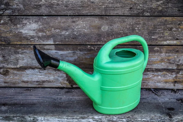 庭の植物を散水するための大きな緑のプラスチック製の散水缶は緑の芝生の上に立っています 夏の庭付け 野生動物の間の緑の庭のWプラスチック製の散水ポット — ストック写真