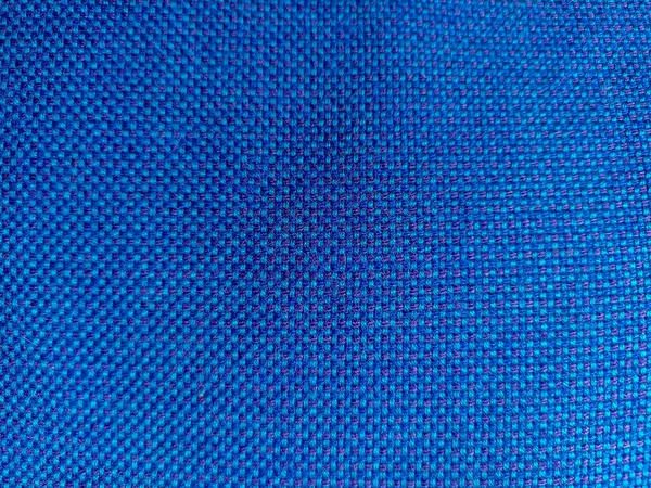 Background from blue fabric in folds. The texture of the fabric. blue fabric cloth background texture .