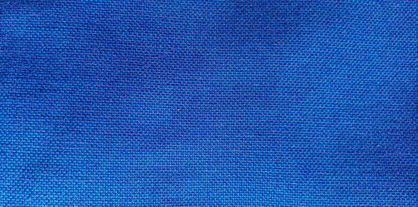 Background from blue fabric in folds. The texture of the fabric. blue fabric cloth background texture .
