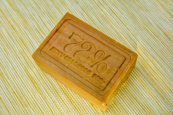 A piece of laundry soap 72 on brown paper. Single piece of eco soap close-up. Natural personal care products.