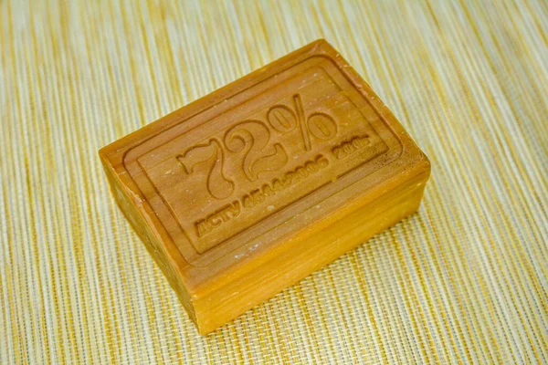 A piece of laundry soap 72 on brown paper. Single piece of eco soap close-up. Natural personal care products.