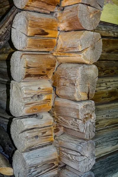 The corner of a house made of wooden logs, the corner joint of a chopped log house.Rustic log cabin wood building structure homestead historic site texture background .