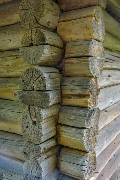 The corner of a house made of wooden logs, the corner joint of a chopped log house.Rustic log cabin wood building structure homestead historic site texture background .